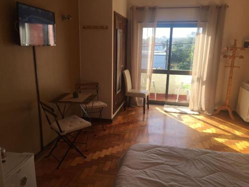 a bedroom with a bed and a table and a window at Morada do Ultramar in Viana do Castelo