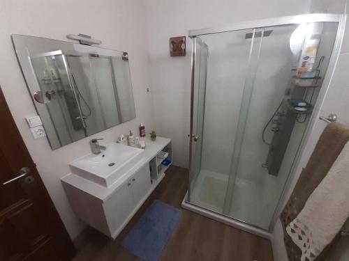 a bathroom with a shower and a sink and a mirror at Morada do Ultramar in Viana do Castelo