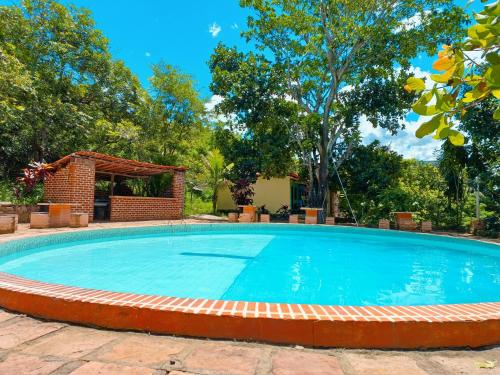 ein großes Schwimmbad in einem Hof mit Bäumen in der Unterkunft Encanto do Parque Hospedagem in Lençóis