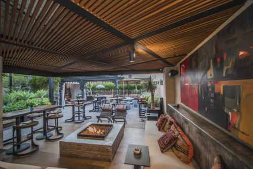 a lobby with tables and chairs and a fireplace at Casa No Name Small Luxury Hotel in San Miguel de Allende