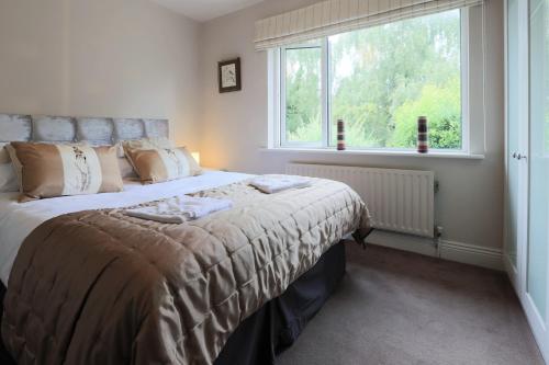 um quarto com uma cama grande e uma janela em Elegant and contemporary large 3 bedroom home em Dublin