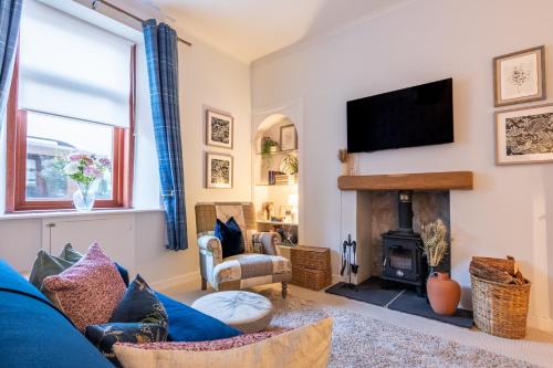 a living room with a blue couch and a fireplace at The Tartan Terrace in Inverness