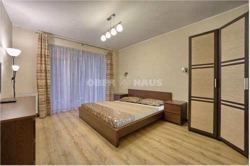 een slaapkamer met een bed en een groot raam bij Gudeliu in Vilnius