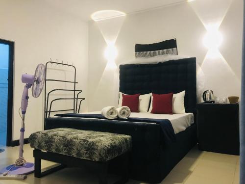 1 dormitorio con 1 cama grande con almohadas rojas en Cloud Nine en Kandy