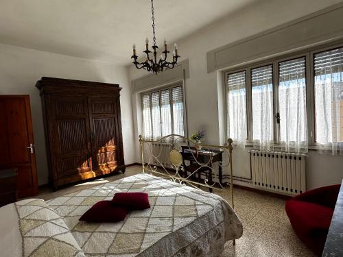um quarto com uma cama grande e um lustre em Casa Valentina em Capannori