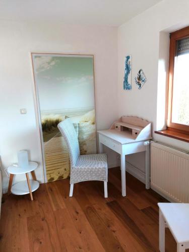 een spiegel in een kamer met een stoel en een bureau bij InnBlick Ferienwohnungen in Gars am Inn