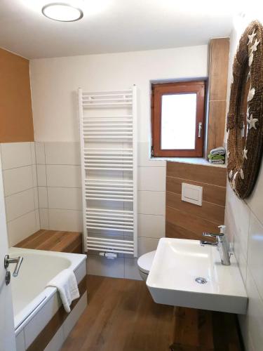 een badkamer met een wastafel, een bad en een toilet bij InnBlick Ferienwohnungen in Gars am Inn