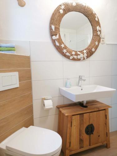 een badkamer met een wastafel en een spiegel aan de muur bij InnBlick Ferienwohnungen in Gars am Inn