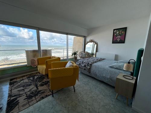 a bedroom with a bed and a view of the ocean at Splendide vue à 180 sur l’océan in Lacanau