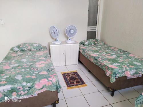 a room with two beds and a fan at Marbelo Pernambuco Hostel in Recife