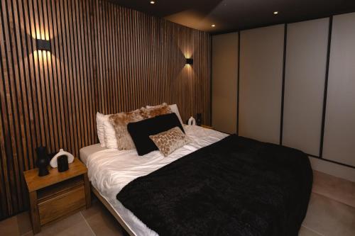 a bedroom with a bed and a wooden wall at B&B Het Rijgebint in Molenaarsgraaf