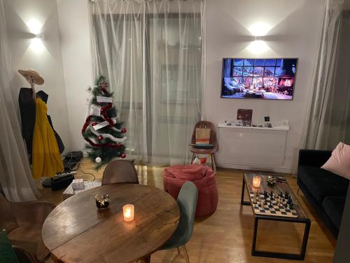 un salon avec un sapin de Noël et une table dans l'établissement Appartement Lyon, à Lyon