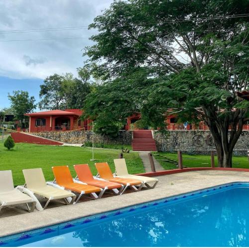 a group of chairs sitting next to a swimming pool at LA QUINTA in Palmillas