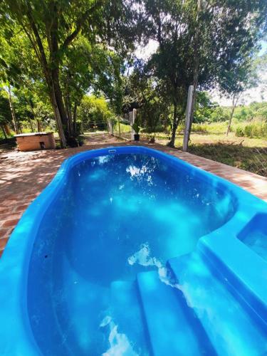 a pool of blue water with trees in the background at Cabañas Carayá in Paso de la Patria