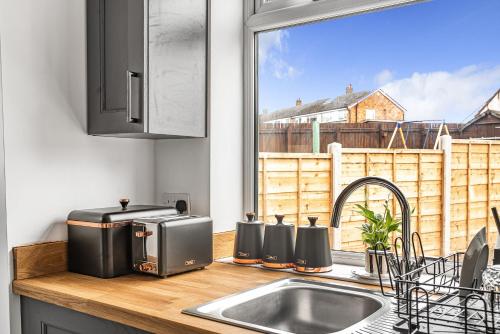 a kitchen counter with a sink and a window at 3-Bed, Sleeps 6, Near M1/M62 in Morley