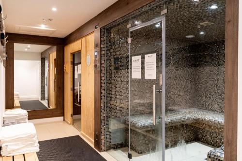 a bathroom with a shower with a glass door at Tranquil Country Retreat With Access to Gym, Golf & Spa in Deanshanger