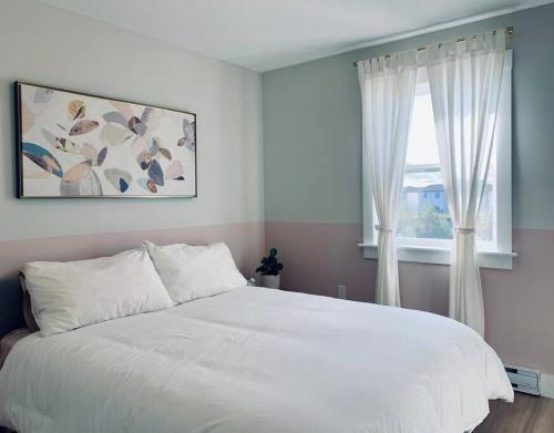 a bedroom with a white bed and a window at Luxury Home with Gym, Sauna, Patio, and AC in Halifax