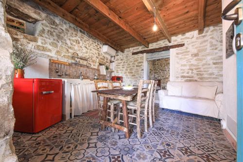 a kitchen with a table and a red refrigerator at Pretziosa in Gergei