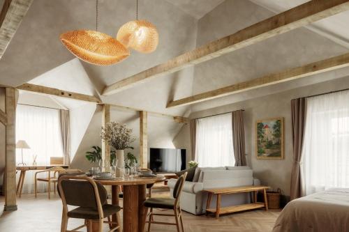 a living room with a dining table and a living room with a bed at Spīdalas nams in Cēsis