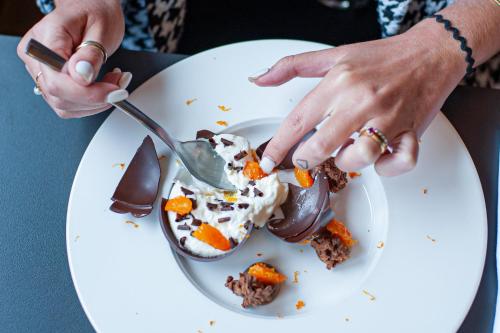 a person eating a dessert on a plate with a spoon at Tribe Carcassonne in Carcassonne