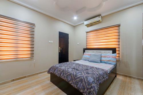 a bedroom with a bed and two windows at Tastefully Furnished 3 Bedroom apartment in Lekki