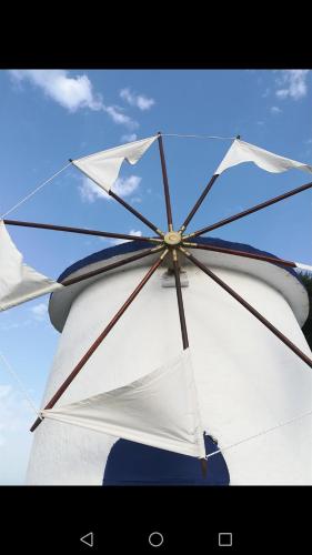 un grand parapluie blanc assis au-dessus d'un bateau dans l'établissement Koralli Sea View Hotel, à Kato Achaia