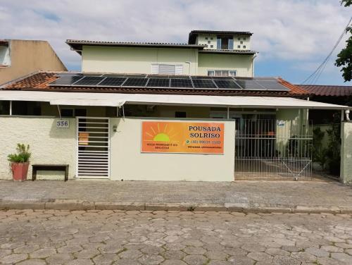 un edificio con paneles solares en su lateral en Pousada Executiva SolRiso Aeroporto Florianópolis, en Florianópolis