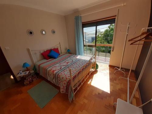 ein Schlafzimmer mit einem Bett und einem großen Fenster in der Unterkunft Morada do Ultramar in Viana do Castelo