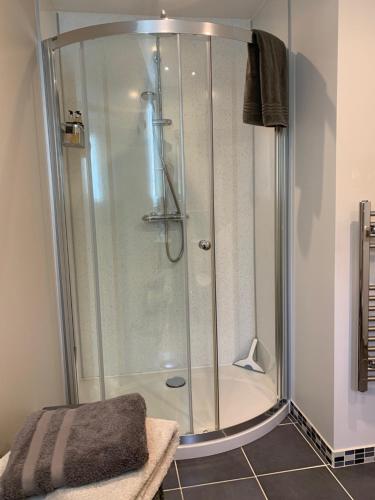a shower with a glass door in a bathroom at The Smiddy in Lochailort