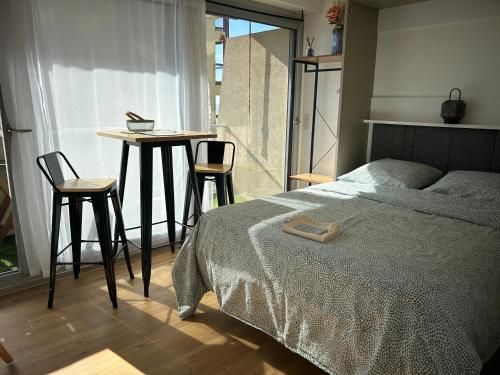 une chambre avec un lit, deux chaises et une table dans l'établissement Cosy studio avec vue sur l'océan, à Lacanau