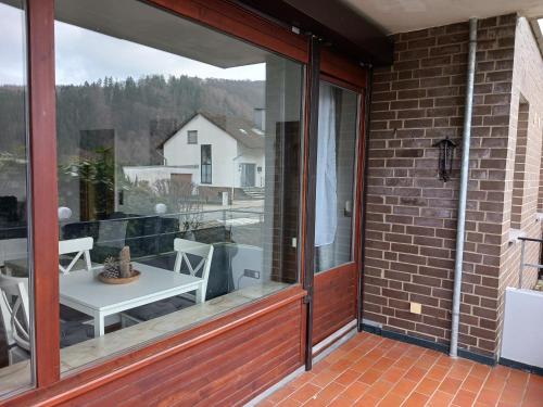 a sliding glass door on a patio with a table at HARZ-LIEBE Lautenthal in Langelsheim