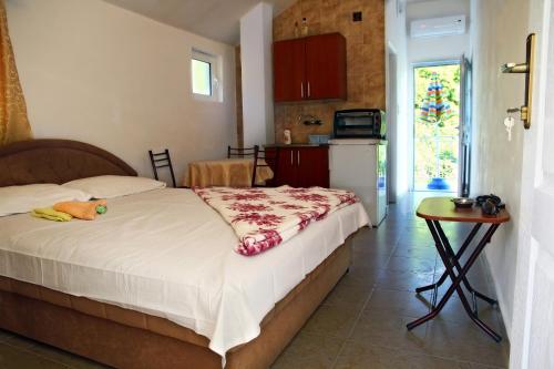 1 dormitorio con cama, mesa y cocina en Apartments Radonjic, en Budva