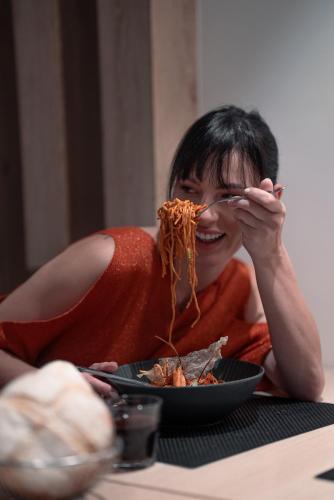 a woman sitting at a table with a plate of spaghetti at New Hotel Piscine Wellness & Spa in Casablanca