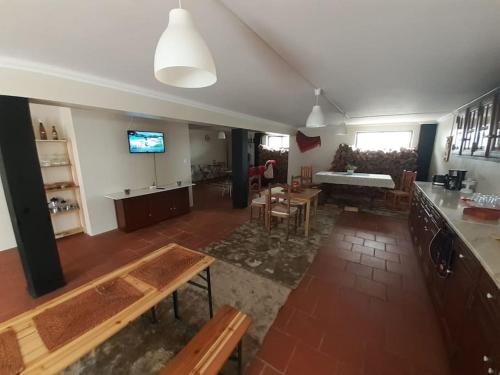 a living room with tables and chairs and a television at Morada do Ultramar in Viana do Castelo