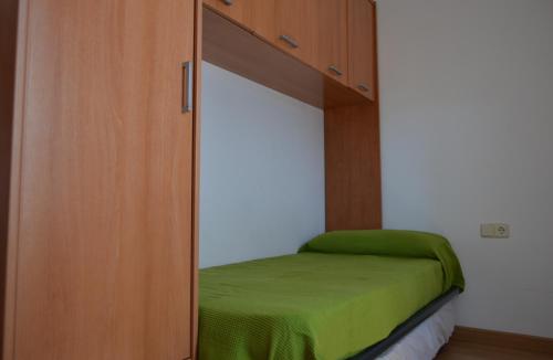 Habitación con armario y cama verde. en Apartamento Borda de Farras, en Bonansa
