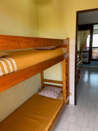 two bunk beds in a room with a doorway at studio cabine avec loggia Cap d Agde in Cap d'Agde