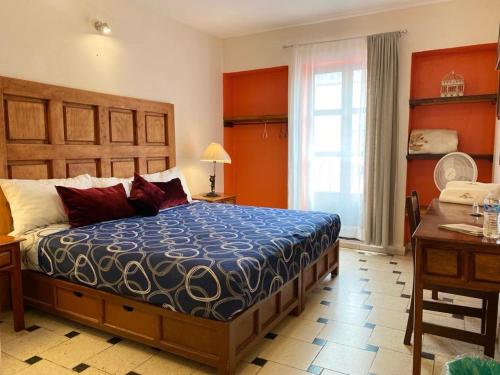 a bedroom with a bed and a desk and a window at Hotel Doña Chela En Calvillo in Calvillo
