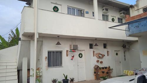 um edifício branco com grinaldas verdes em POUSADA MEGA em Marataízes