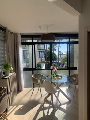 Estudio Puerto Deportivo Marbella في مربلة: غرفة طعام مع طاولة وكراسي زجاجية