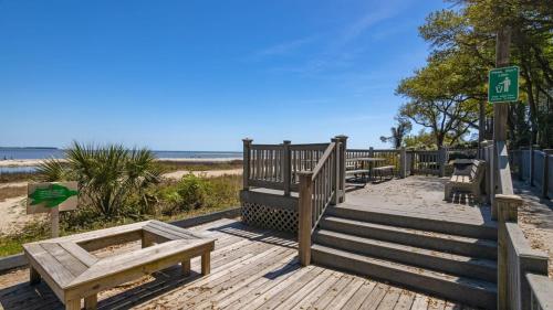a wooden boardwalk with benches on the beach at Walk to the Beach Waterfront Oasis in Hilton Head Island
