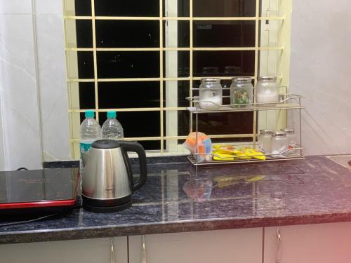 - un comptoir de cuisine avec une cafetière et une fenêtre dans l'établissement Bangalore Cozy Homestay Near IKEA & BIEC, à Bangalore