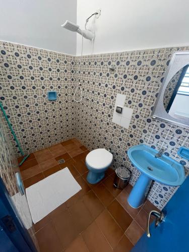 uma casa de banho com um WC azul e um lavatório. em Pousada Praiamar em São Sebastião