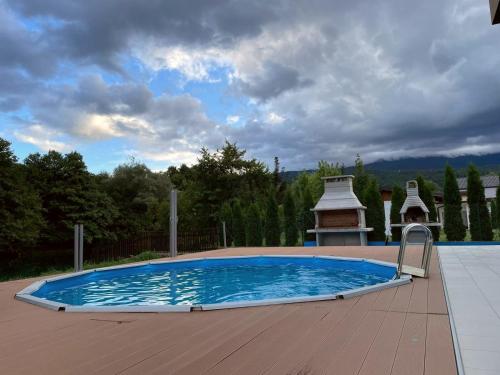 a large swimming pool with a gazebo in a yard at Lohovo Villa Bukva in Otoka