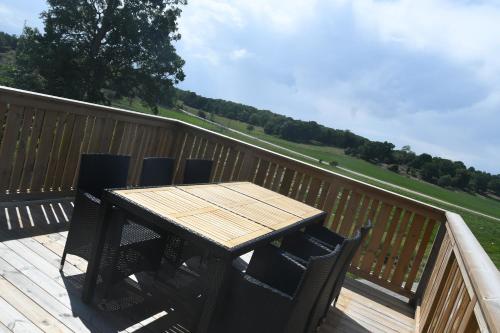 a wooden table and chairs on a deck at Apartment Berghem Grönadal Nättraby in Nättrabyhamn