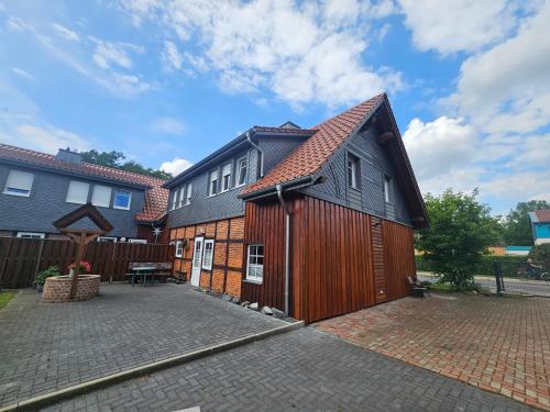 a large wooden house with a patio in a yard at Gästehaus Treder in Wienhausen