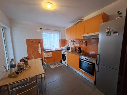 a small kitchen with a refrigerator and a table at Apartment Sweet Home in Ponta Delgada