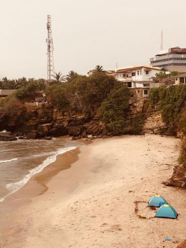 two umbrellas on a sandy beach next to the ocean at Rising Phoenix in Accra