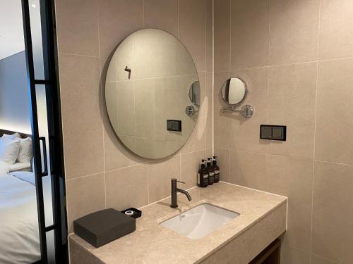 a bathroom with a sink and a mirror at The Marevo in Suwon