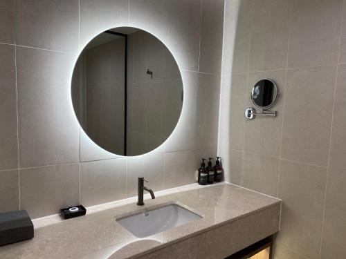 a bathroom with a sink and a mirror at The Marevo in Suwon