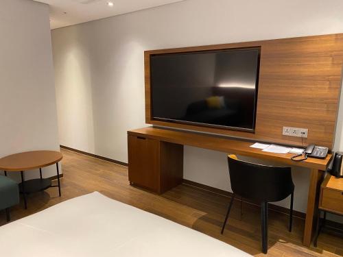 um quarto com uma televisão de ecrã plano numa secretária em The Marevo em Suwon